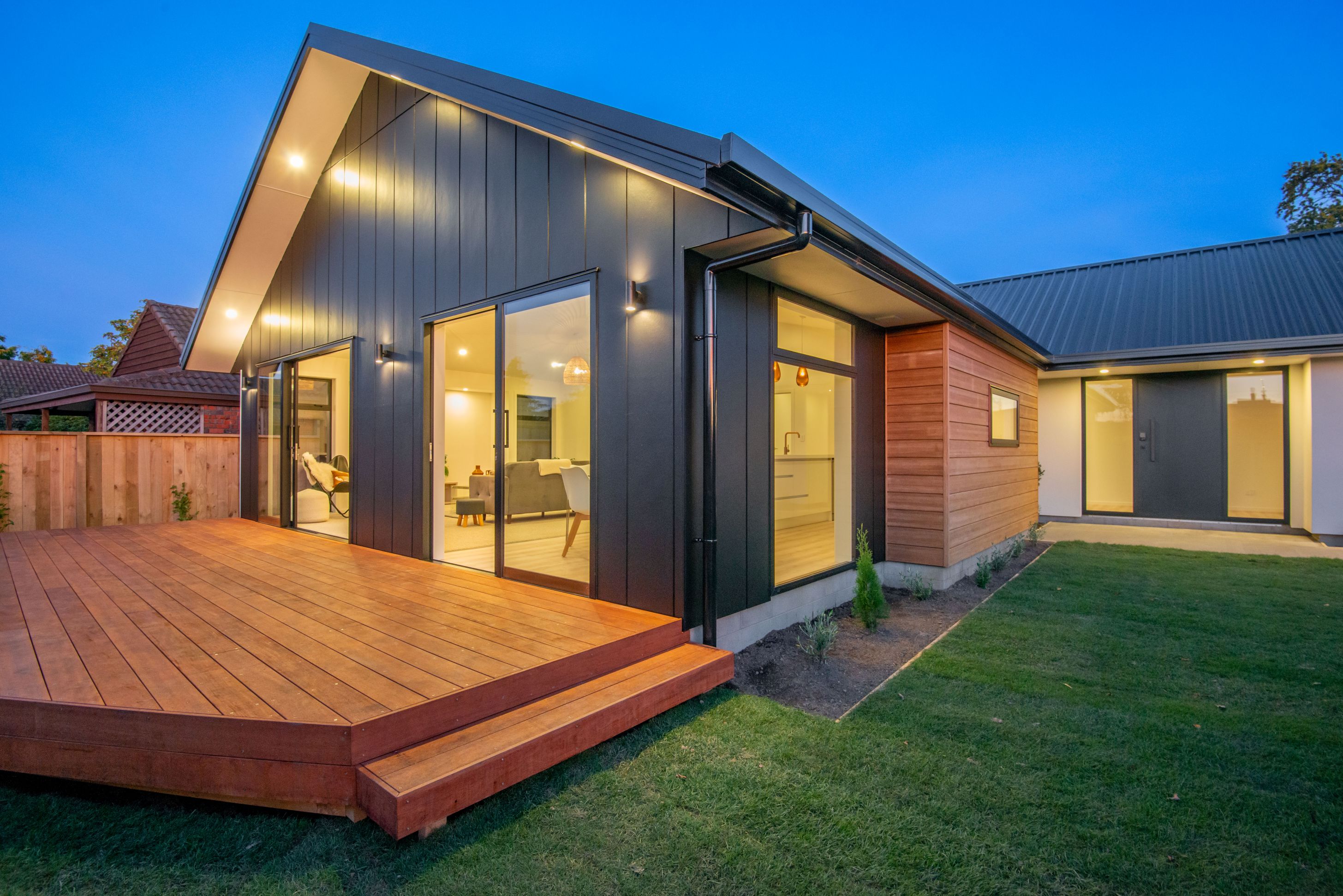 stria-cedar-external-cladding-kwila-deck-metal-roofing-entry-door-landscaping-lawn-grass